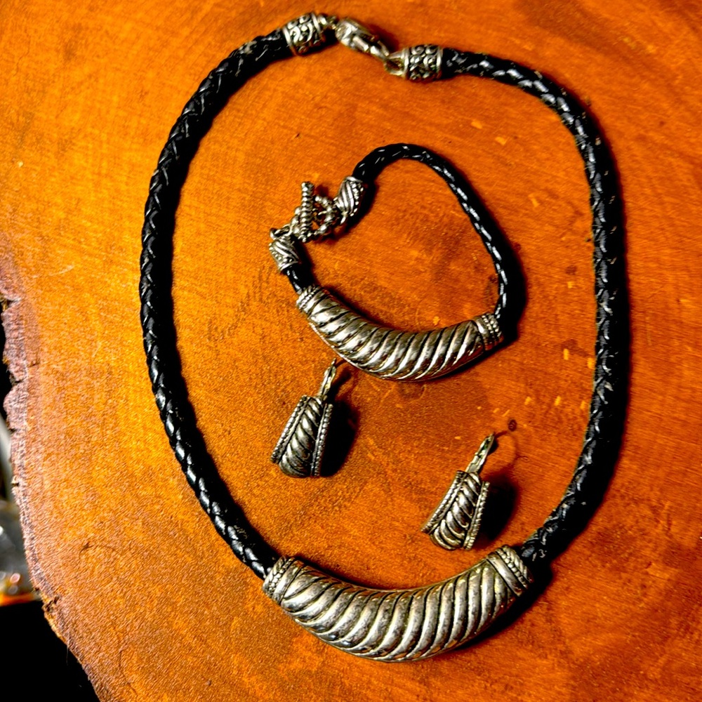 Striking silver and leather matching necklace, earrings, and bracelet.
